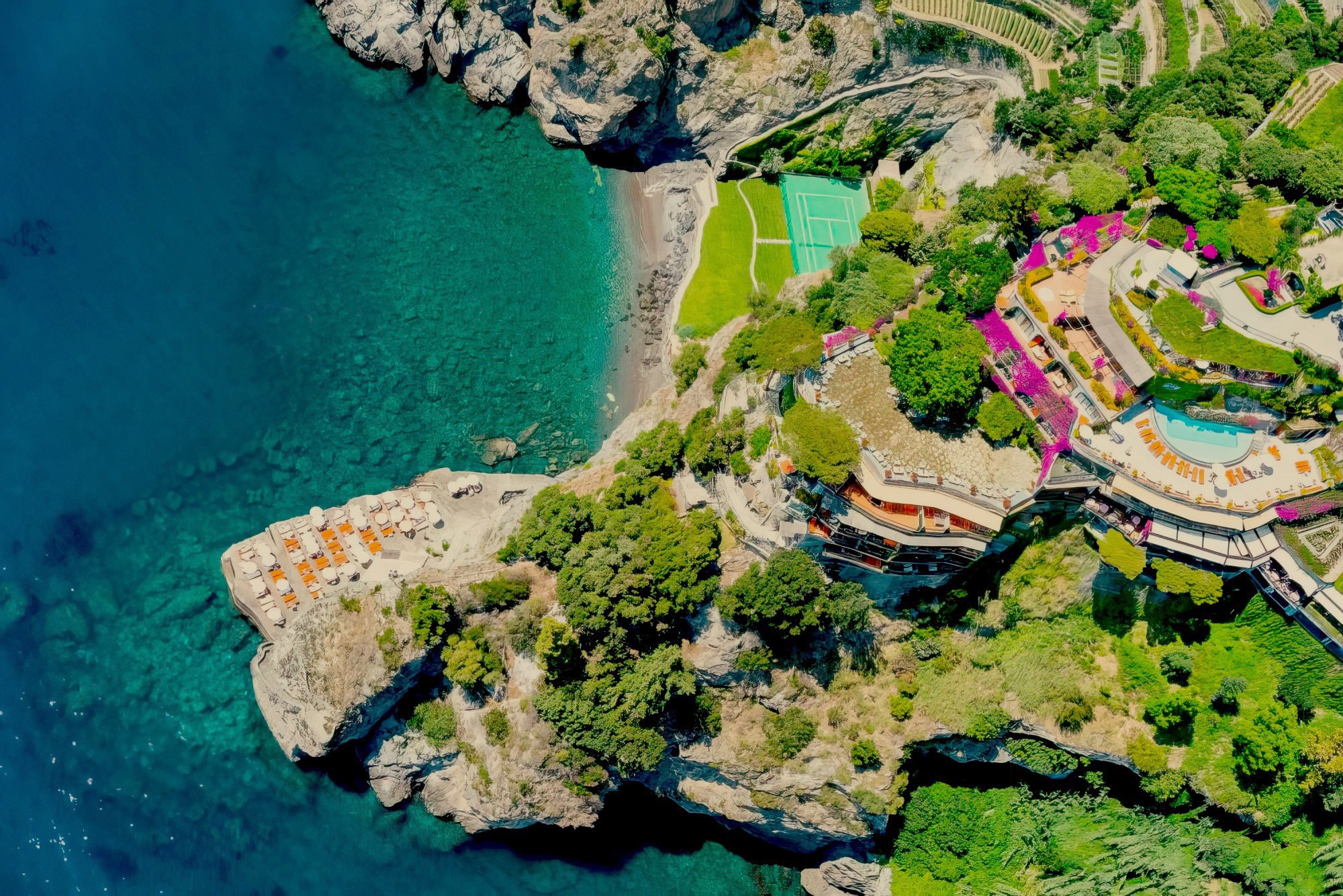 Two women sitting at a modern table talking with a city view behind them.